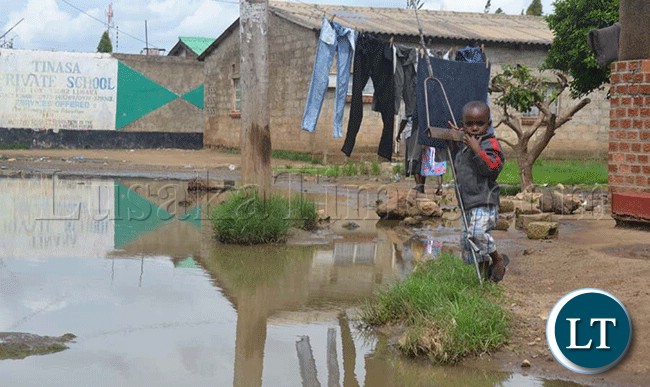 File:The heavy rainfall being experienced in some parts of the country such have caused severe floods. Here, a child plays on a Zesco pylon cable while on the ground is a flood of stagnate rainwater in Kanyama Township