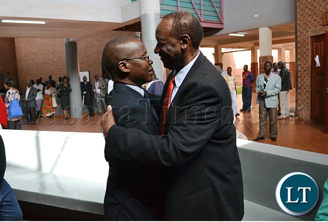 Former Information and Broadcasting Services Minister Ronnie Shikapwasha (right) and freelance journalist Chanda Chimba III hug at the Lusaka magistrate’s court complex