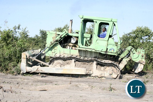 Zambia National Service (ZNS) Caterpillar operator clearing the area for the new ultra Mongu Stadium shortly after the launch