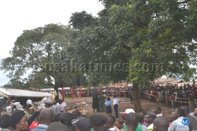 Police seal off the accident scene from members of the public while some people help remove dressed chickens from the container
