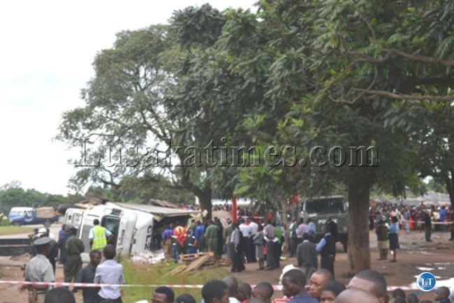 Police seal off the accident scene from members of the public while some people help remove dressed chickens from the container