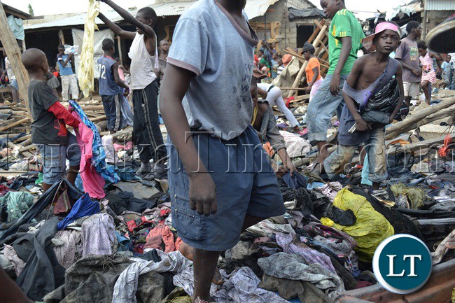Lusaka’s Mandevu township residents salvage clothes from burnt debris of second hand clothes and shoes. The warehouse in which the clothes were stored caught fire last night from a suspected candle flame