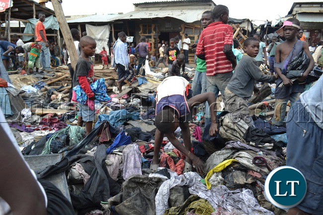 Lusaka’s Mandevu township residents salvage clothes from burnt debris of second hand clothes and shoes. The warehouse in which the clothes were stored caught fire last night from a suspected candle flame