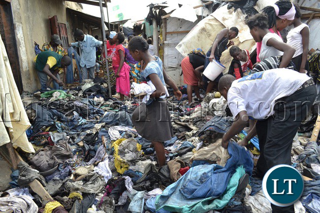 Lusaka’s Mandevu township residents salvage clothes from burnt debris of second hand clothes and shoes. The warehouse in which the clothes were stored caught fire last night from a suspected candle flame