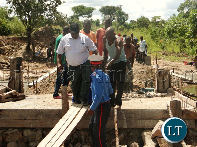 KASAMA District Commissioner (DC) crossing Chikosho Bridge in Kasama which is being constructed by the utilisation of Constituency Development Funds (CDFs) in Bululu ward in Kasama Central Constituency in which member of the Community have shown full participation