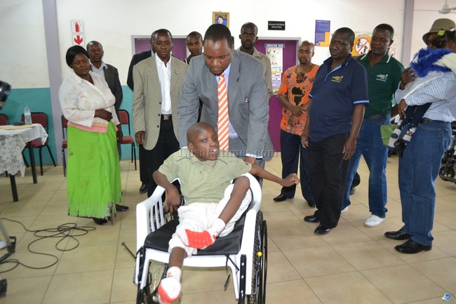 Matero Member of Parliament Miles Sampa pushes a child on one of the 60 wheel chairs donated by Children International which he handed over to children with disabilities in George Township in Lusaka recently