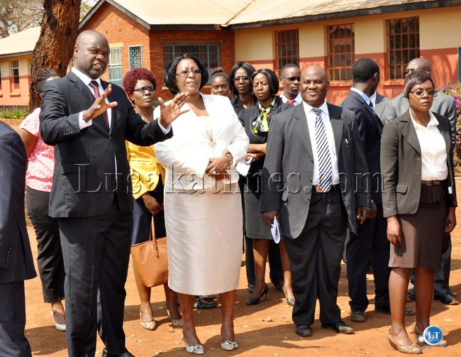 First Lady Dr Christine Kaseba listens to David Kaunda Technical High School deputy Head Teddy Chibwe as out-going Christopher Mvula listens during tour of the school where she gave a Lecture to pupils and Youths under the theme: " Young People are Key agents in the fight against cancer." in Lusaka on August 15,2013. The First Ladies interactive programme with Pupil's was organised by Infotainment Movement in Union with the smart 29EARS Zambia-Picture by THOMAS NSAMA