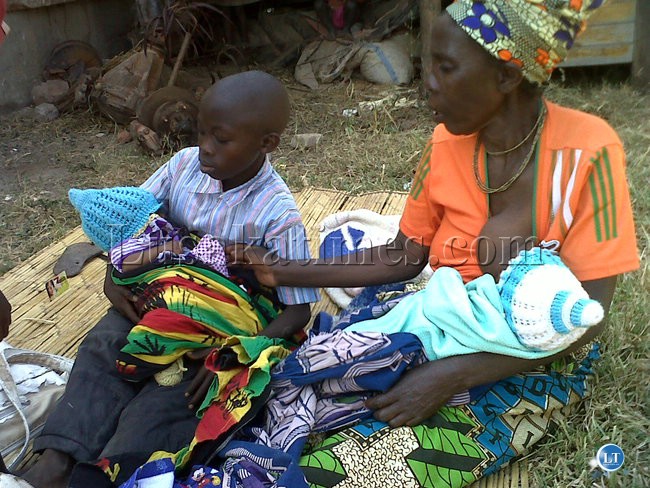 Ms Christine Chisha breastfeeds her grandson as his twin sister waits for her turn in the arms of cousin.