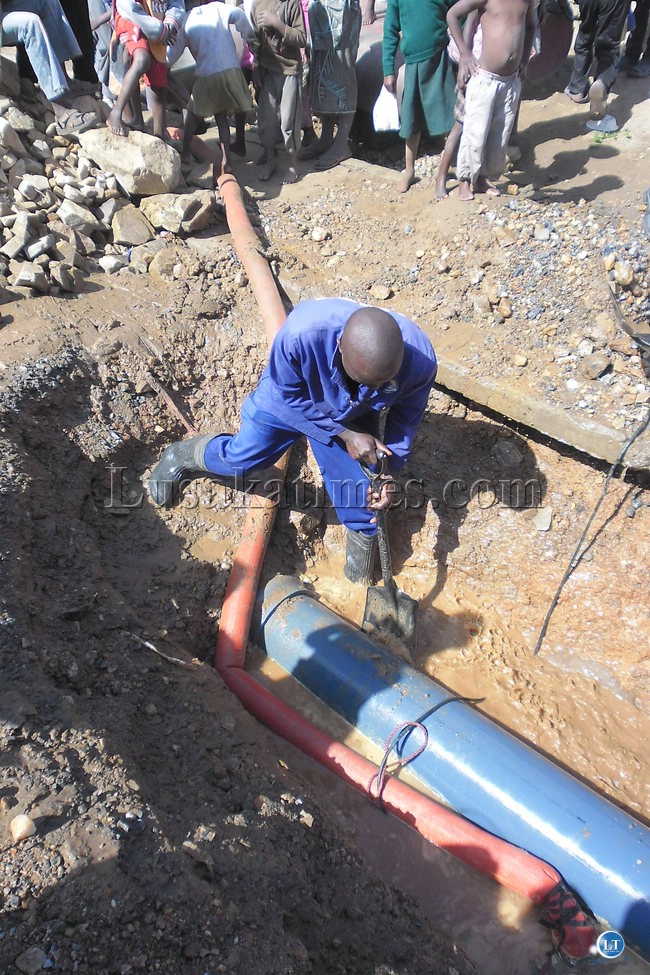 Lusaka Water and Sewerage worker fixing a leaking pipe
