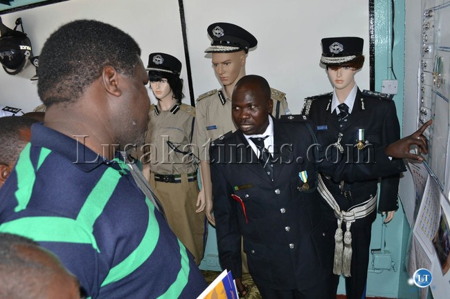 A police officer explains how the police service operates to members of the public visiting the police service pavilion in the Lusaka Showground.