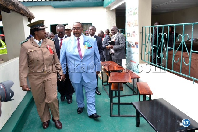 Defense Minister Geoffrey Mwamba is taken on a conducted tour of the Zambia Prisons Service pavilion by Zambia Prisons Service Public Relations Officer Doreen Ngoma at the Zambia Agriculture and Commercial Show in Lusaka.