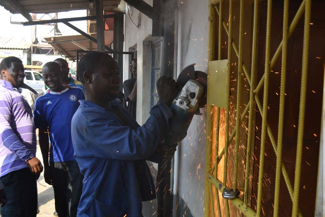 A MAN grinds off the welding that attached the grill gate to the door frame at the Patriotic Front (PF) Lusaka District Office A MAN grinds off the welding that attached the grill gate to the door frame at the Patriotic Front (PF) Lusaka District Office