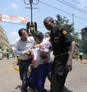 A security officer helps a wounded woman outside Nairobi's Westgate Mall, an upscale shopping mall where a deadly shooting erupted on Saturday. (Jason Straziuso/Associated Press)