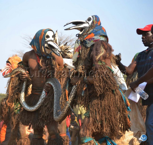 nyau dancers with a python snake