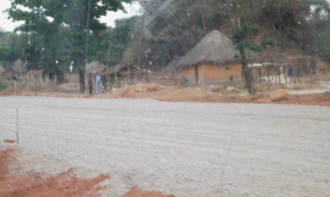 Part of the Pedicle Road spread with tarring stone materials with villagers in the background. The possible benefits that will come to them in the settlements along the road when the road is completed.