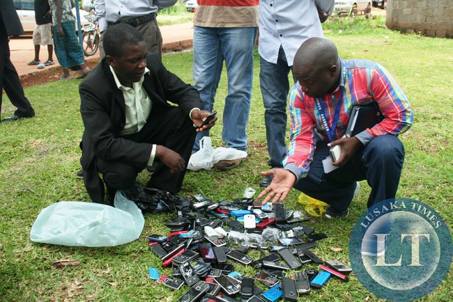 AN officer from the Zambia Police Intellectual Property Unit in Eastern Province and Samsung Zambia representative, Jonathan Nsama (r), display some counterfeit Samsung phones at Chipata Central Police Station last Thursday. This was during the certification to determine the genuine phones from the counterfeit ones.
