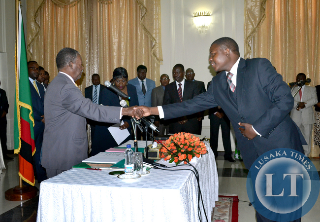 President Michael Sata receives an affidavit from newly appointed Public Policy Specialist Pride Kabuswe during the swearing in ceremony at State House today
