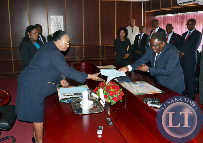 Acting Chief Justice Lombe Chibesakunda receives an affidavit from Lusaka Judge-in-Charge Ernest Mutiyo during a swearing in ceremony of members of a tribunal tasked to investigate Tourism and Arts Minister Sylvia Masebo at the High Court building in Lusaka