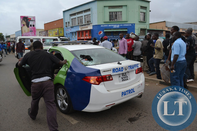 An onlooker checks the RTSA patrol car after the crowd smashed its rear wind shield in the fracas