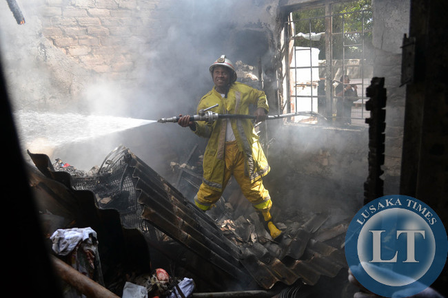 International Women's Day turned tragic for a Rhodespark family in Lusaka when a fire burned their house to ashes. Above, a firefighter tries to dowse the inferno in the main bedroom where the roof had curved in due to the intensity of the blaze