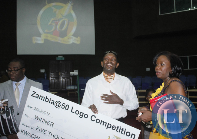 Designer of Zambia Golden Jubilee logo poses for a photo with Namakau Kapizhya during the launch of the jubilee celebrations