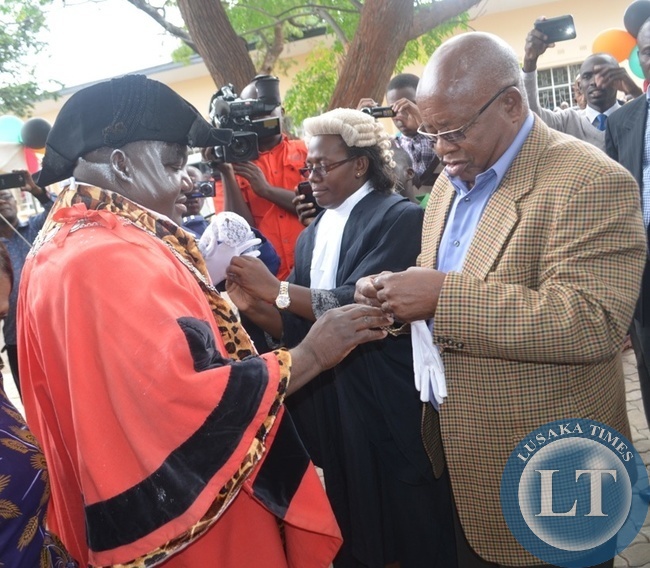 Southern Province Minister Daniel Munkombwe (right) dresses the newly elected mayor for Livingstone Milford Maambo (left) during the installation of the mayor and deputy mayor in the tourist capital