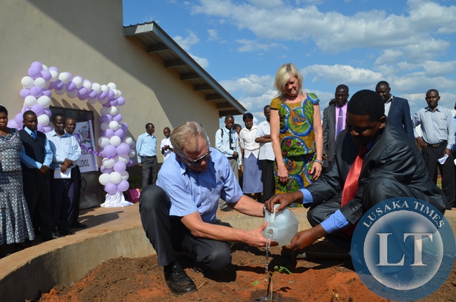 Terry Schwartz and School head teacher Howard Mbula water a tree during the official launch of Terry Schwartz SDA Secondary School In the middle is Terry Schwartz SDA Secondary School
