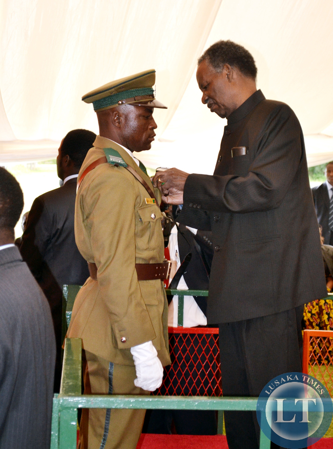 President Michael Sata honours Justine Muwana with the President's Medal for Gallantry at the investiture ceremony at State House