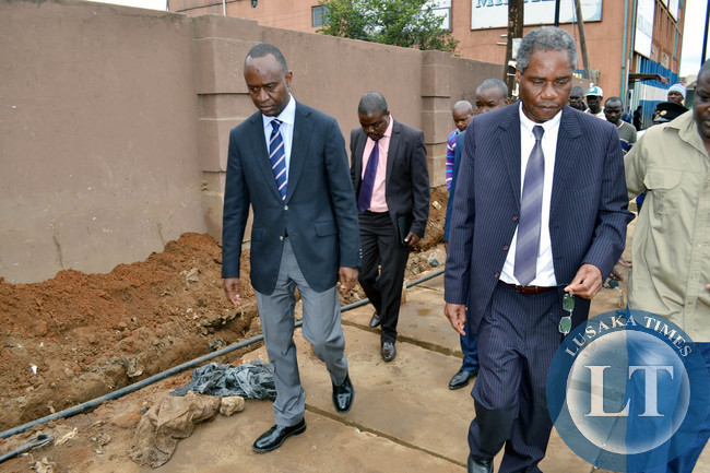 Local Government Minister Emmanuel Chenda (right) and Lusaka Mayor Mulenga Sata inspect a drainage system at Northmead shopping centre