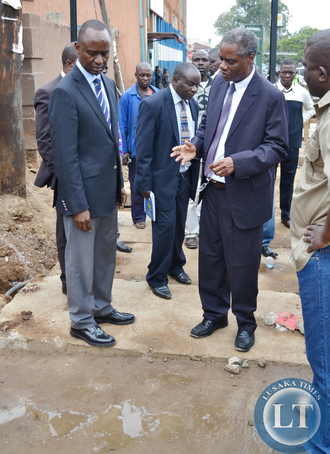 Local Government Minister Emmanuel Chenda (right) talks to Lusaka Mayor Mulenga Sata during an inspection a drainage system at Northmead shopping centre