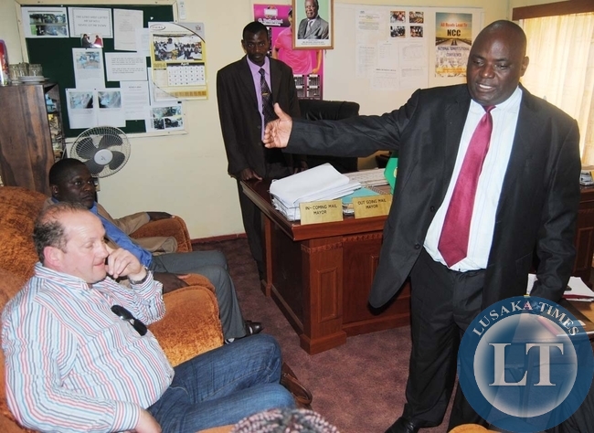 Choma Town Clerk Mwiya Mwiya (right) confers with Truck Sales 2000 limited managing director William Simpson, the principal supplier of earth-moving equipments procured by Choma and Kalomo councils which are marooned in Namibia. Next to Mr Simpson is Choma former Mayor Jackson Makwamba while standing is Choma Mayor Profester Mwaanga in Choma