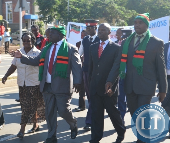 Transport Minister Yamfwa Mukanga (second from far left), Livingstone Town Clerk Vivian Chikoti (far left), Livingstone Deputy Mayor Fred Sikazwe (second from far right) and Livingstone District Commissioner Omar Munsanje (far right) marching during the 2014 labour day celebrations in the tourist capital