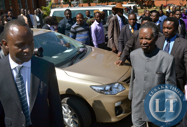 President Michael Sata is accompanied by Lusaka Mayor Mulenga Sata (left) as he left the Lusaka High Court