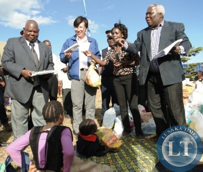 Northern Province Minister Freedom Sikazwe (r) inspects a grinding miller at Mapalo Day Care Centre in Kasama today before presenting an assortment of goods worth K50 donated by TBEA .Looking on is Centre Director Chanda Chintu and TBEA Commercial Manager Author Liu