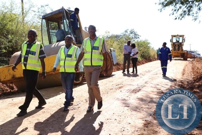 Lusaka Province Minister Phillip Kosamu flanked by deputy ps Bright Nundwe during the tour of roads in kafue district