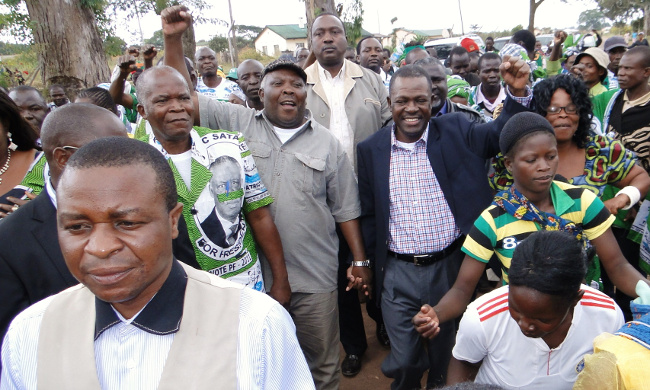 Patriotic Front (PF) Secretary, General Wynter Kabimba (in blue jacket) hand in hand with Northern Province Minister, Freedom Sikazwe (also with a clinched fist) being welcomed in Luwingu district yesterday by party officials and cadres. Mr Kabimba also addressed rally at President's Park before officiating at the PF district conference