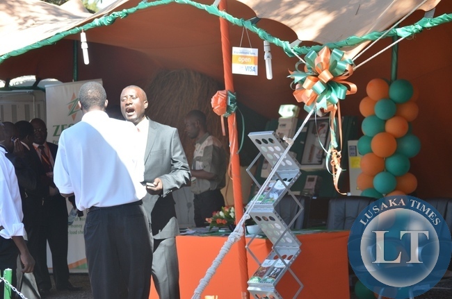 ZESCO spokesperson Henry Kapata (right) talks to a client at his firm's pavilion yesterday during the ongoing eighth Southern Tourism, Agricultural and Commercial Show Society (STACSS) in Livingstone