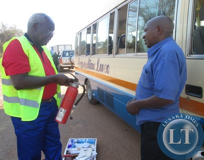 captions Communications and Transport Deputy Minister Panji Kaunda yesterday mounted a Road Block at Prospect police Camp near Kabwe where he Impouded a number of Vehicles which had faults .In the picture, Mr Kaunda inspects the fire Extinguisher from a Rosa Bus while the Driver of a Bus looks on captions Communications and Transport Deputy Minister Panji Kaunda yesterday mounted a Road Block at Prospect police Camp near Kabwe where he Impouded a number of Vehicles which had faults .In the picture, Mr Kaunda inspects the fire Extinguisher from a Rosa Bus while the Driver of a Bus looks on
