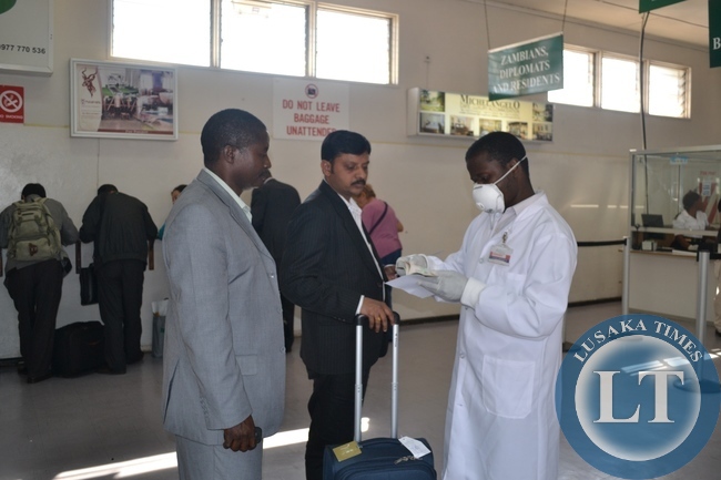 FILE: A HEALTH official going through a medical card of a passenger who had just disembarked an international flight at the Simon Mwansa Kapwepwe International Airport in Ndola . The process is part of screening for Ebola at entry points into Zambia.