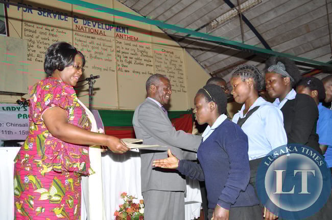 First Lady Dr Christine Kaseba presents certificates to pupils at the just ended Teachers/ Community Leaders/ Pupils Mentorship training programme at Chinsali Girls Secondary school in Muchinga Province on August 15,2014 -Picture by THOMAS NSAMA