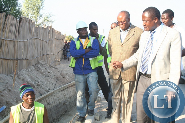 Mongu Municipal Council Town Clerk Timothy Mambalakata (r) leads Western Province Minister Richwell Siamunene (l) during the inspection tour of the multi-million kwacha Mongu Township Roads Project in Mongu District, Western Province,