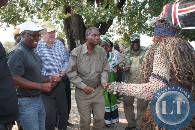 Local Government and Housing minister Emmanuel Chenda (second right) and and North-Western province minister Nathaniel Mubukwanu (left) joins Vice –President Dr Guy Scott (second left) dancing with a Makishi at Liyovu school grounds. This was during the drumming up support for the Zambezi west parliamentary by-election in Zambezi