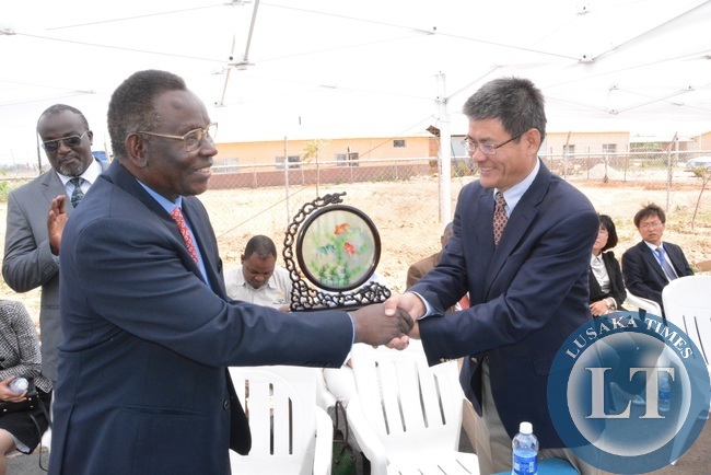 Minister of Health Joseph Kasonde shakes hands with Chinese Ambassador to Zambia Yang Yaoming shortly after receiving a double Fish ornament during the unveiling ceremony of Medical Park at multi facility Economic Zone