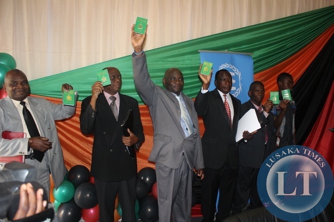 ome of the former Angolan refugees displaying the residency permits during the hand-over ceremony