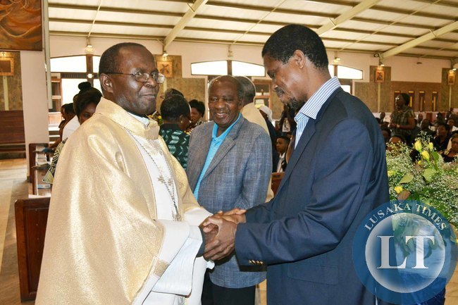 Defence Minister Edgar Lungu (right) shakes hands with Archbishop of Lusaka Telesphore Mpundu (left) as Finance Minister Alexander Chikwanda looks on at the memorial service of the aate Benjamin Mwila at the Cathedral of the Chile Jesus
