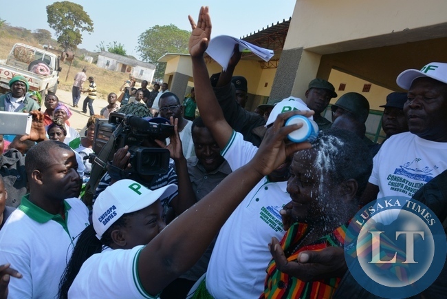 Wife of Davis Chisopa pours white powder on him after he emerged victorious in the just ended Mkushi north bye election.