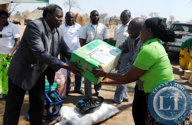 CHIEF Chikanta hands over a sprayer on behalf of MRI Seed limited to a local farmer Kenmax Hamoonga and his wife, Angela who lost 5,000 by 50 kg bags of maize after fire swept through a storage shed recently at his farm in Kalomo.