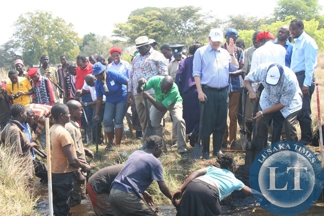 World Bank Group Executive Director Dr. Denny Kalyalya (r) participates in the clearing of the 20 kilometre Natonga Canal during the visit of the Zambia Strengthening Climate Resilience Project in the Barotse Sub-Basin in Imalyo area of Mongu District, Western Province