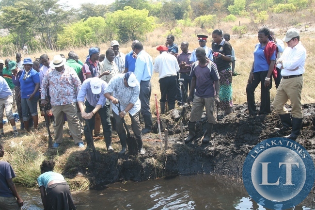 World Bank Group Executive Director Dr. Denny Kalyalya (r) participates in the clearing of the 20 kilometre Natonga Canal during the visit of the Zambia Strengthening Climate Resilience Project in the Barotse Sub-Basin in Imalyo area of Mongu District, Western Province