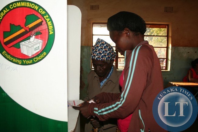 JOYCE Daka, assists her visually impaired grandmother, Tiwamyenji Miti ( right) cast her vote at Mtaya Basic school polling station in a Kasenengwa parliamentary by-election in Chipata